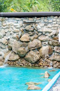 a stone wall next to a swimming pool at Samui Hills Resort in Amphoe Koh Samui +6 photos