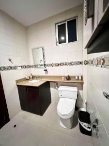 a bathroom with a toilet and a sink at Samborondón Luxury Room by Adriana in SamborondÃ³n