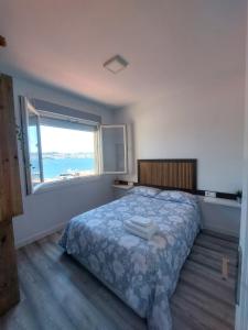 Un dormitorio con una cama y una ventana grande. en El nido de la gaviota, en Moaña 4 fotos más