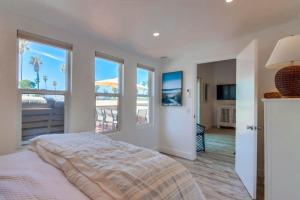 a bedroom with a bed with windows and a balcony at Jetty View 1 in San Diego