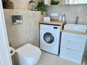 a bathroom with a washing machine and a sink at Apartament BEACH GLOW-Sand Dunes Dziwnów EPapartamenty in Dziwnów