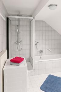 a white bathroom with a shower and a red towel at Tor zu Frankreich - Neuburg am Rhein in Neuburg