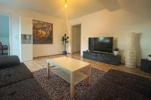 a living room with a coffee table and a flat screen tv at Tor zu Frankreich - Neuburg am Rhein in Neuburg