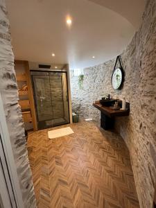 a bathroom with a sink and a stone wall at Chambre privée avec salle de bain tourelle in Domagné +9 photos