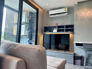 a living room with a couch and a large window at Room in Kamala at Citygate Condo in Kamala Beach