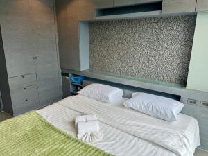 a large bed with white sheets and pillows on it at Room in Kamala at Citygate Condo in Kamala Beach