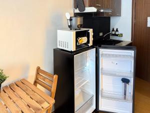 a microwave sitting on top of a refrigerator in a kitchen at Destiny Hotel - 1601 in Manila