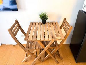a wooden table with two chairs and a potted plant at Destiny Hotel - 1601 in Manila +4 photos