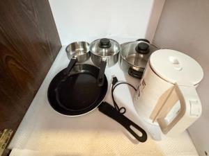 a stove top with a pot and pans on it at Destiny Hotel - 1601 in Manila