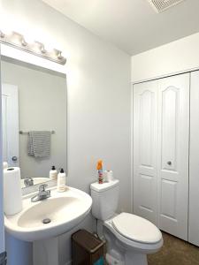 a bathroom with a white toilet and a sink at Maison Acropole in Gatineau +16 photos