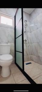 a bathroom with a shower and a toilet in it at Leaves Apartments in Paramaribo