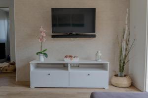 a white entertainment center with a tv on a wall at Apartamento Rincón de la calma in Alcudia