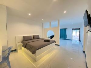 a bedroom with a bed and a table and a tv at Pun's Garden Home in Ban Sao Thong