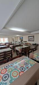 a dining room with tables and chairs with flowers on them at Pousada Caminho do Mar in Torres