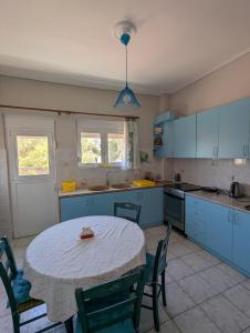 een keuken met een tafel en een tafel met stoelen bij Comfortable waterfront cottage in Paralía Rachón