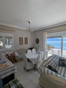 een woonkamer met een tafel en uitzicht op de oceaan bij Comfortable waterfront cottage in Paralía Rachón +15 foto's