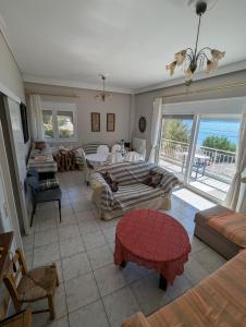 een woonkamer met een bank en een tafel bij Comfortable waterfront cottage in Paralía Rachón