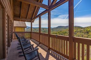 a deck with chairs and a view of the mountains at Mountain Echoes in Sevierville