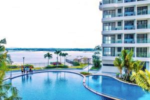 a large swimming pool next to a tall building at Dooga Ins-Retro Wonderland Seaview Bathtub by Doogahome Homestay in Johor Bahru