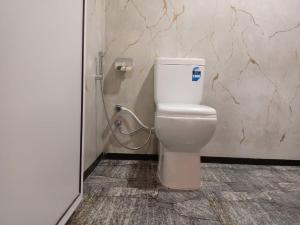 a bathroom with a white toilet in a stall at The Onisula Guest House in Ahangama