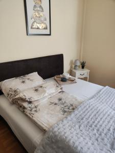a bed with a white comforter and pillows on it at SkyBreak Apartment in Ledine