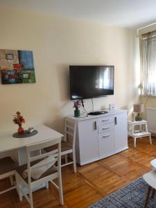 a living room with a tv on top of a white cabinet at SkyBreak Apartment in Ledine