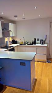 a kitchen with white cabinets and a blue counter top at Ensuite Room in Southampton - Ocean Village in Southampton
