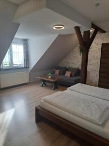 a bedroom with a bed and a couch and a tree at Hotel Altes Badehaus in Bad Dürrenberg +52 photos