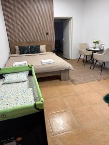 a bedroom with a bed and a table and chairs at River Garden House in Vidin