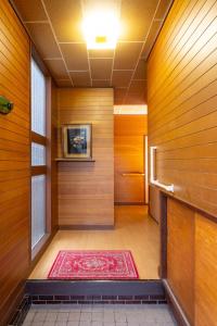 a hallway with a red rug on a wooden wall at 甲府木ノ間Kofu Konoma in Kofu