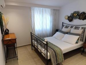 Un dormitorio con una cama y una mesa y una ventana. en Belvedere Luxury Suite, en Tríkala