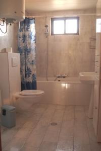 une salle de bains avec baignoire, toilettes et lavabo dans l'établissement House Eleni, à Sikia 32 autres photos