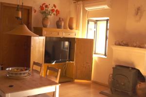 un salon avec une table et une grande télévision dans l'établissement House Eleni, à Sikia