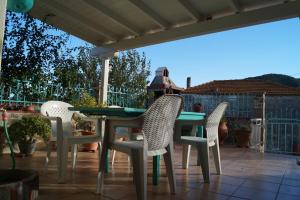 une table et quatre chaises sur la terrasse dans l'établissement House Eleni, à Sikia