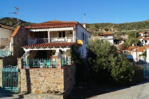 une maison blanche avec un balcon sur une colline dans l'établissement House Eleni, à Sikia