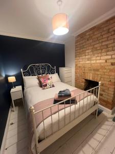 ein Schlafzimmer mit einem großen Bett und einem Kamin in der Unterkunft Life's A Beach - cosy, luxury cottage in Ashley Cross, Poole in Parkstone