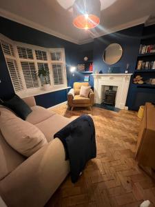ein Wohnzimmer mit einer Couch, auf der ein Bein stand in der Unterkunft Life's A Beach - cosy, luxury cottage in Ashley Cross, Poole in Parkstone