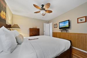 a bedroom with a white bed and a ceiling fan at Island Sands 210 · IS 210 OceanFront Condo Expansive Ocean Views in Maalaea +49 photos