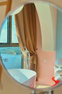 a mirror reflection of a window with a curtain at Dooga Ins-Retro Pastelland Seaview Bathtub by Doogahome Homestay in Johor Bahru