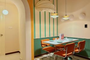 a dining room with a table and orange chairs at Dooga Ins-Retro Pastelland Seaview Bathtub by Doogahome Homestay in Johor Bahru