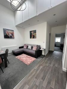 a living room with a couch and a table at Beeches Bach, 1 bedroom cottage with hot tub in Prestatyn