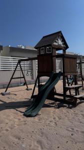 a playground with a slide and a play structure at Al Marsa Beachfront Villa in Al Sharqiyah +7 photos