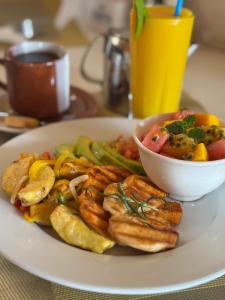 a plate of food with shrimp and a bowl of vegetables at Albatina Place in Nakasongola