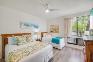 a bedroom with two beds and a window at Grand Champions 163 · GC 163 2BD Wailea Condo w AC Pool Close to in Wailea +50 photos