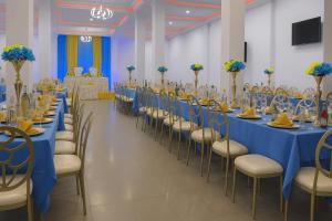 a large banquet hall with blue tables and chairs at Hôtel Foham Oasis in Bandjoun
