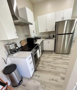 a kitchen with white cabinets and a stainless steel refrigerator at The studio for all your needs in Sacramento