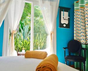 a bedroom with a bed and a large window at Gîtes Atemoya. Petit Bas Vent Fort Royal. in Deshaies +54 photos