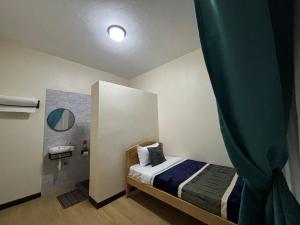 a small bedroom with a bed and a mirror at Albatina Place in Nakasongola