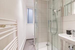 een witte badkamer met douche en wastafel bij Hyper Centre Studio Strasbourg Cathedral in Straatsburg