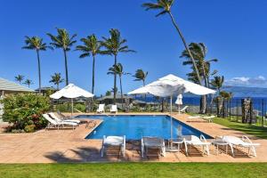 una piscina con sillas y sombrillas en Kapalua Bay Villas 36G5 · KBV 36G5 1BD Condo w Unobstructed Ocea, en Kahana